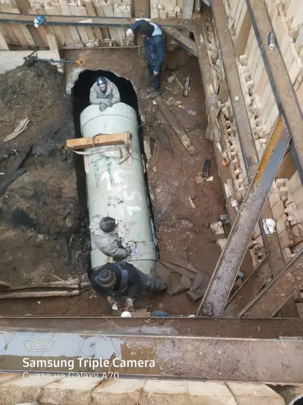 Переход под дорогой в футляре: спуск трубы в приёмный котлован краном