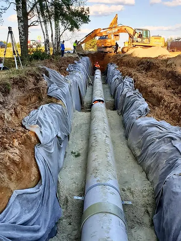 Строительство наружных сетей водоснабжения — труба водовода в траншее на геотекстиле