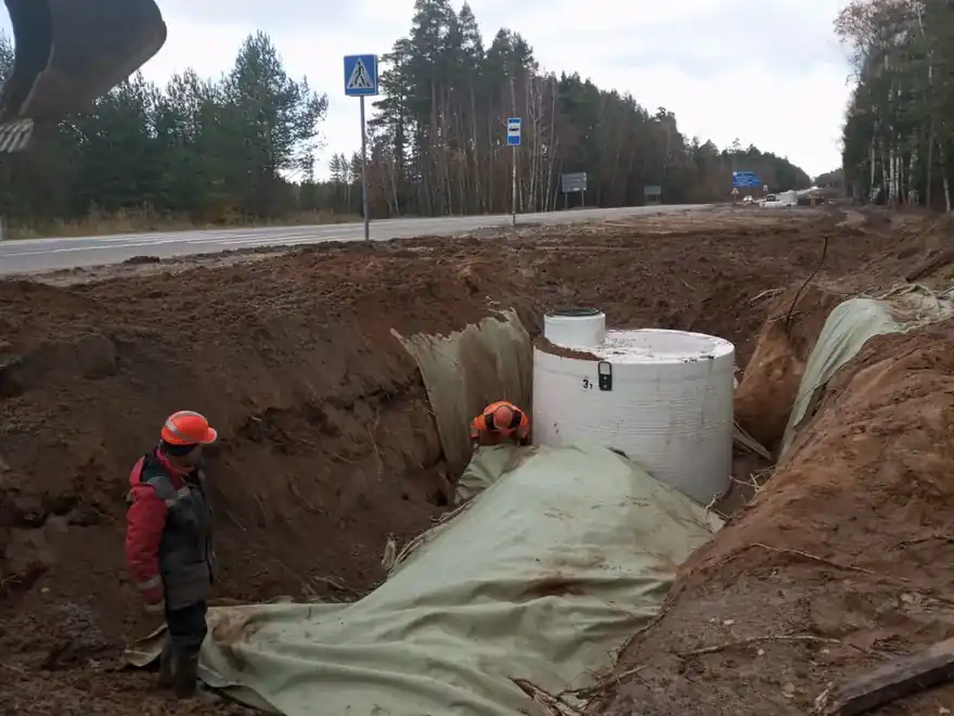 Устройство канализационных колодцев — белый колодец у дороги, рабочий