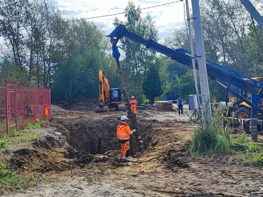 Строительство магистральных водоводов — кран и бригада на трассе трубопровода